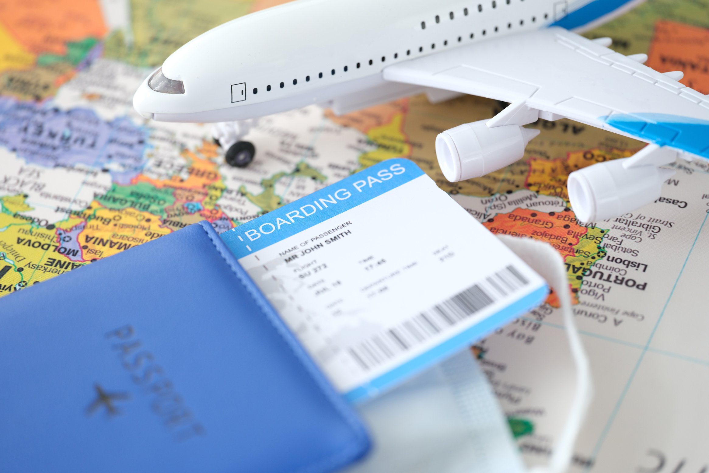 Passport Plane Ticket and Toy Plane Stands on World Map Closeup